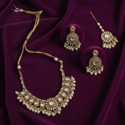 04 womlysh kundan gold toned metal faux pearls traditional bib set gold white necklace set top down view 1749